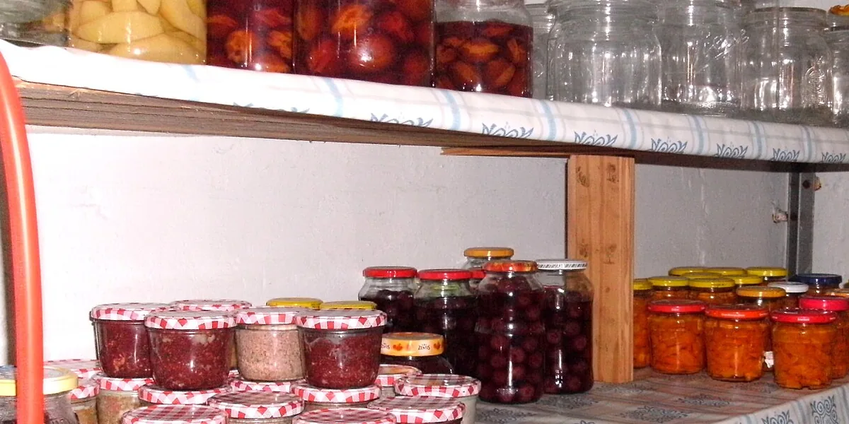 Estantes de madera con frascos de conserva y tapas de colores